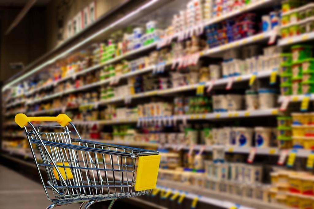 Supermarket employee organizing fresh produce on shelves